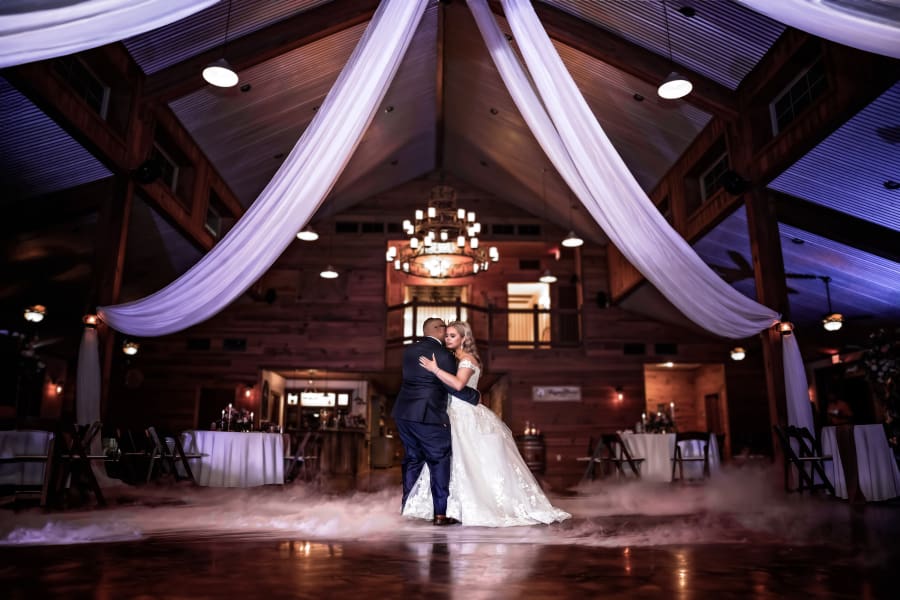 Ahnvee photography wedding reception bride and grooms first dance underneath grand arched ceilings with large draped curtains fog