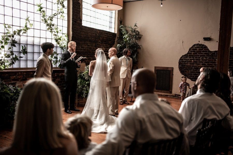 ahnvee photography wedding ceremony bride and groom reading vows at alter large window