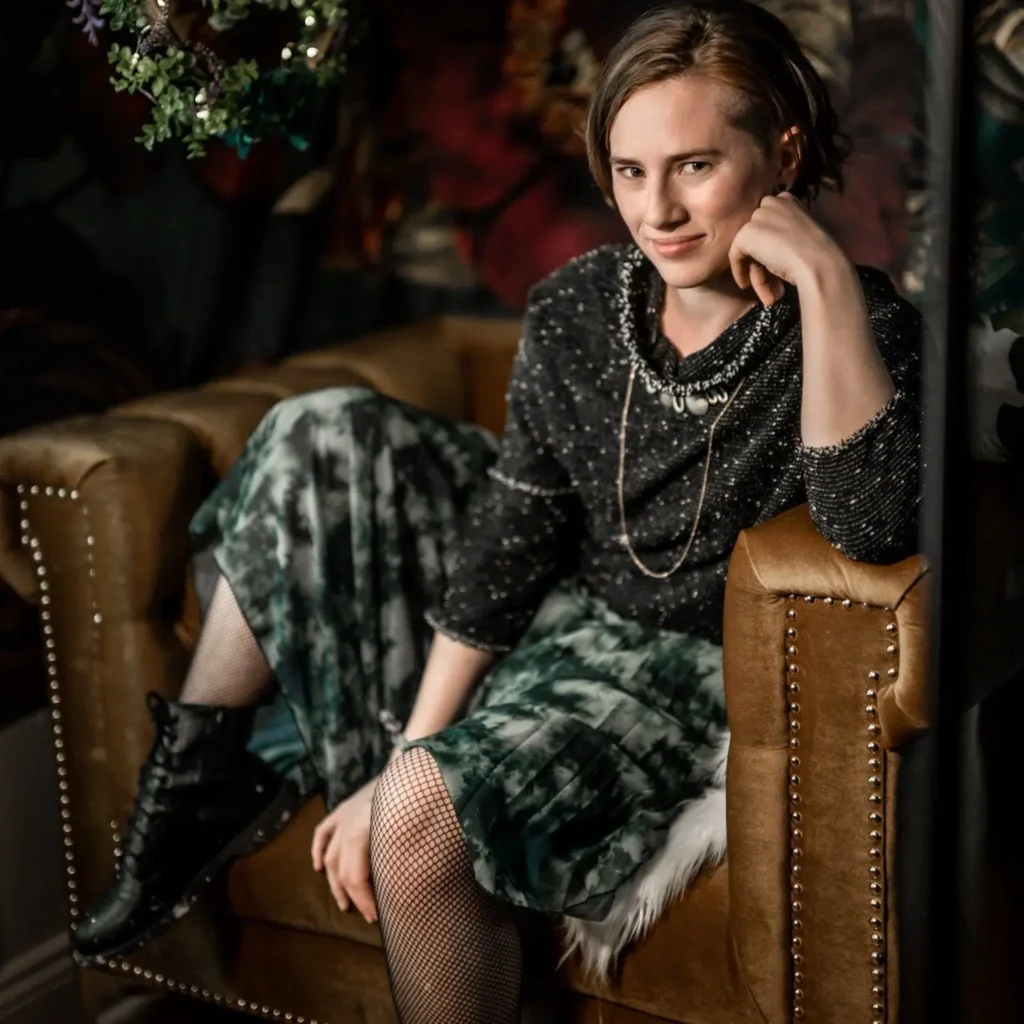 Executive assistant for Ahnvee Photography, a creative Louisiana photographer, seated in a styled, editorial portrait with moody lighting
